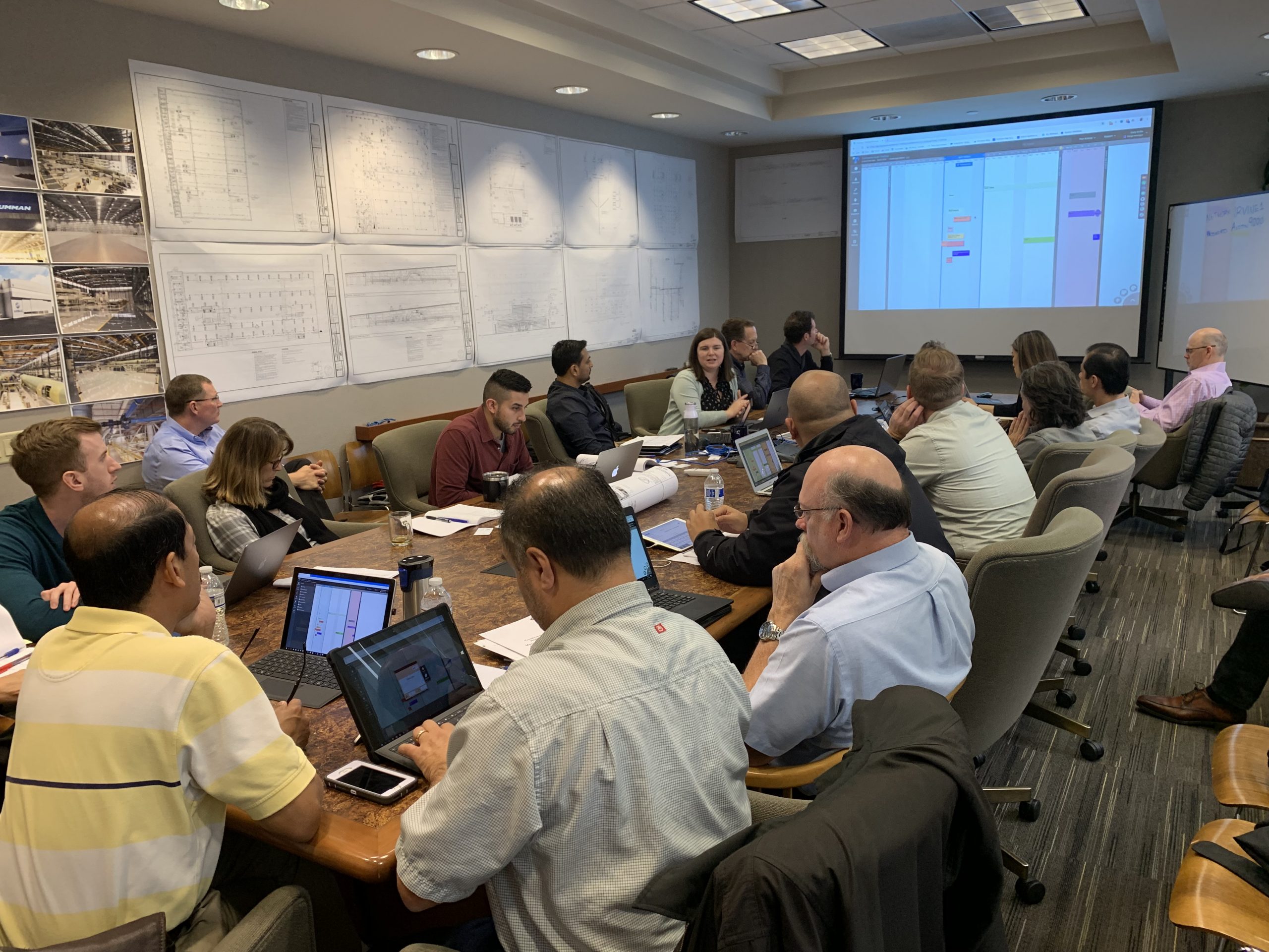 Team of engineers review plans on screen