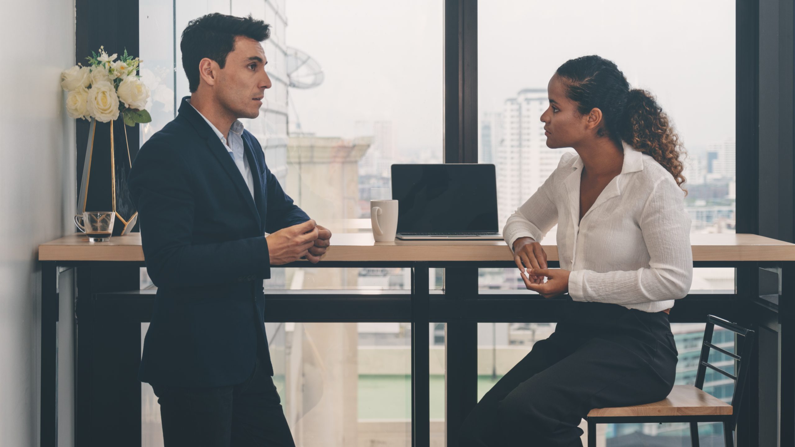 two people talking laptop on table